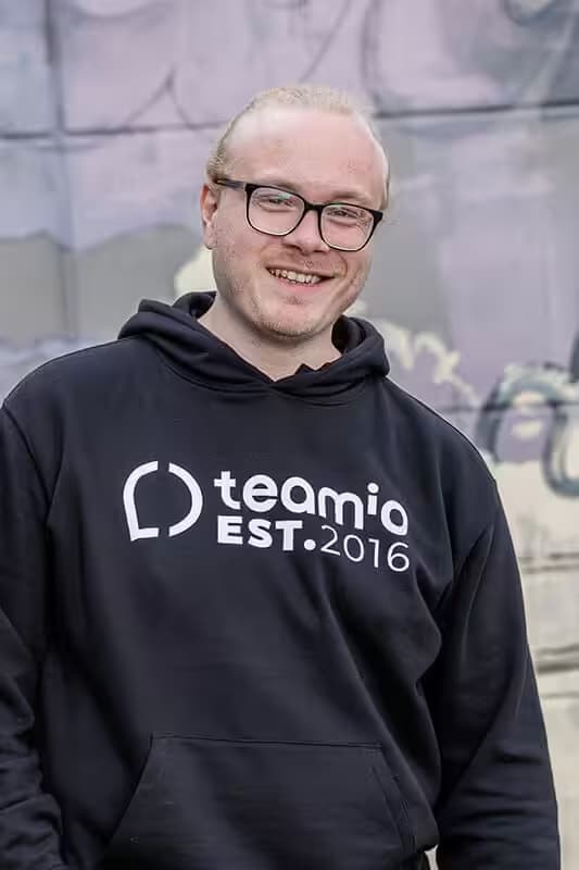 Smiling man wearing a teamio hoodie.