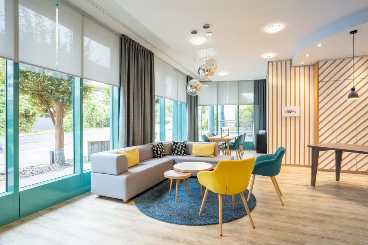 FOUR Essen City Centre - Moderne Lounge mit großen Fenstern und Designermöbeln