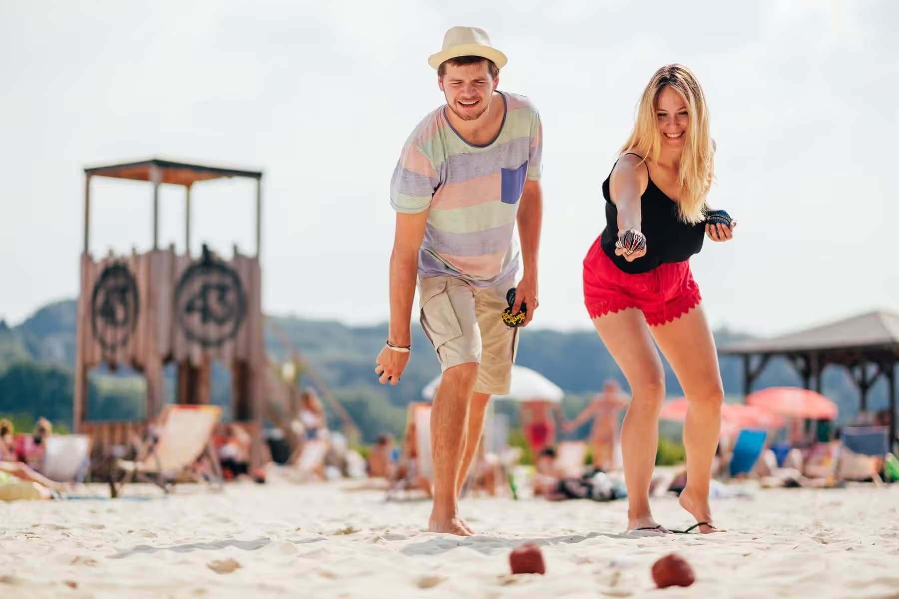 Teilnehmende spielen Boule im Sand bei den Beach Games