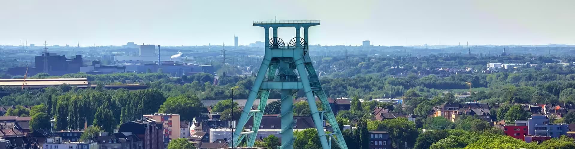Bergbau-Industriedenkmal mit städtischem Hintergrund und Himmel