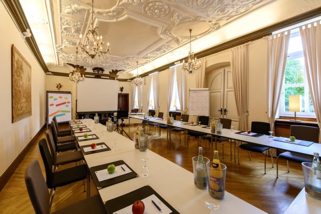 Meeting room with chandeliers and U-shaped seating at the Parkhotel Engelsburg