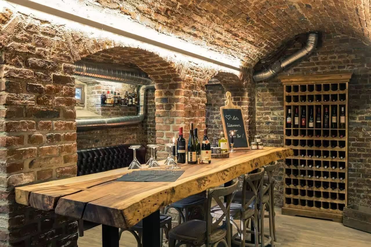 Gemütliche Kellerbar mit Holztisch und Weinauswahl