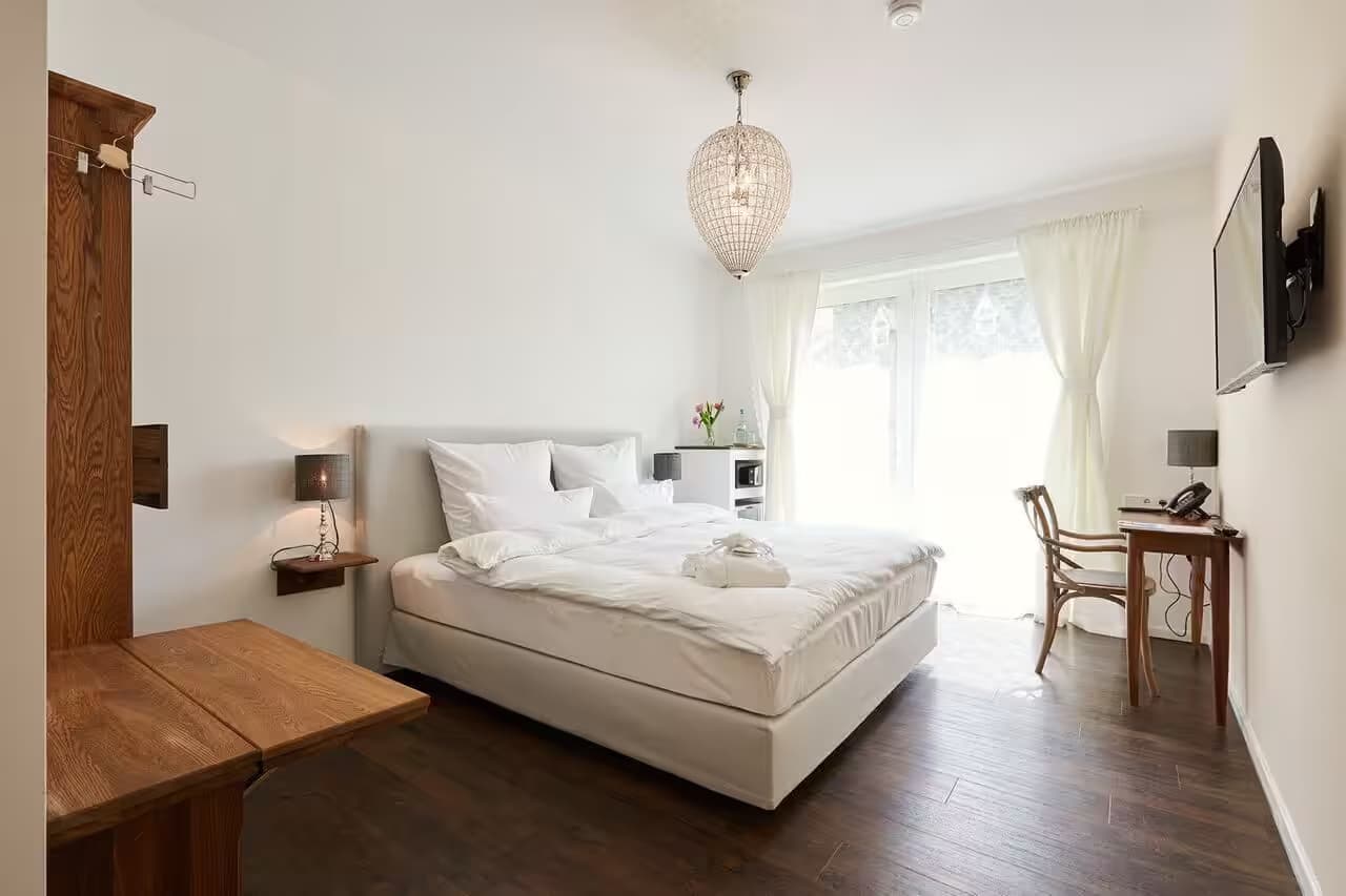Helles Schlafzimmer mit Doppelbett und Holzmöbeln.