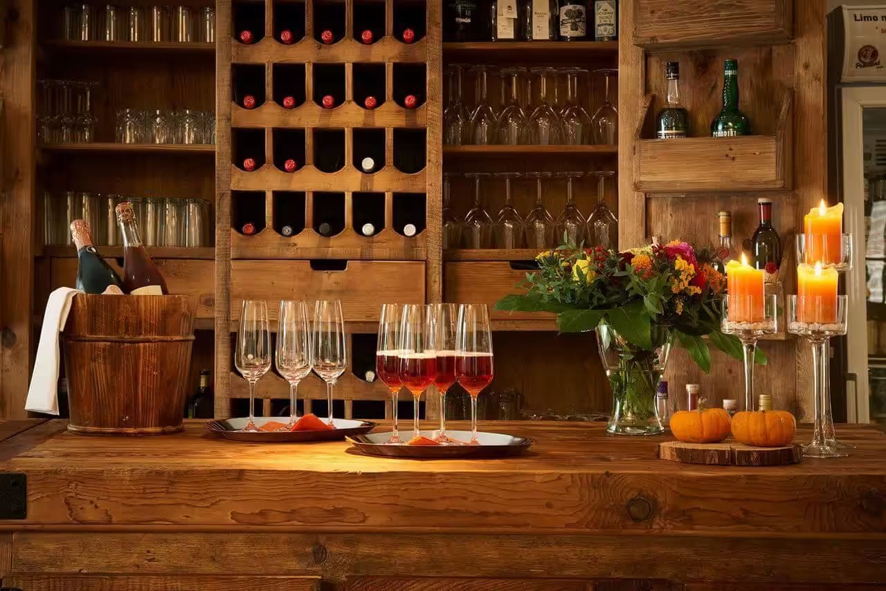 Gemütliche Bar mit Kerzen und Weinflaschen.