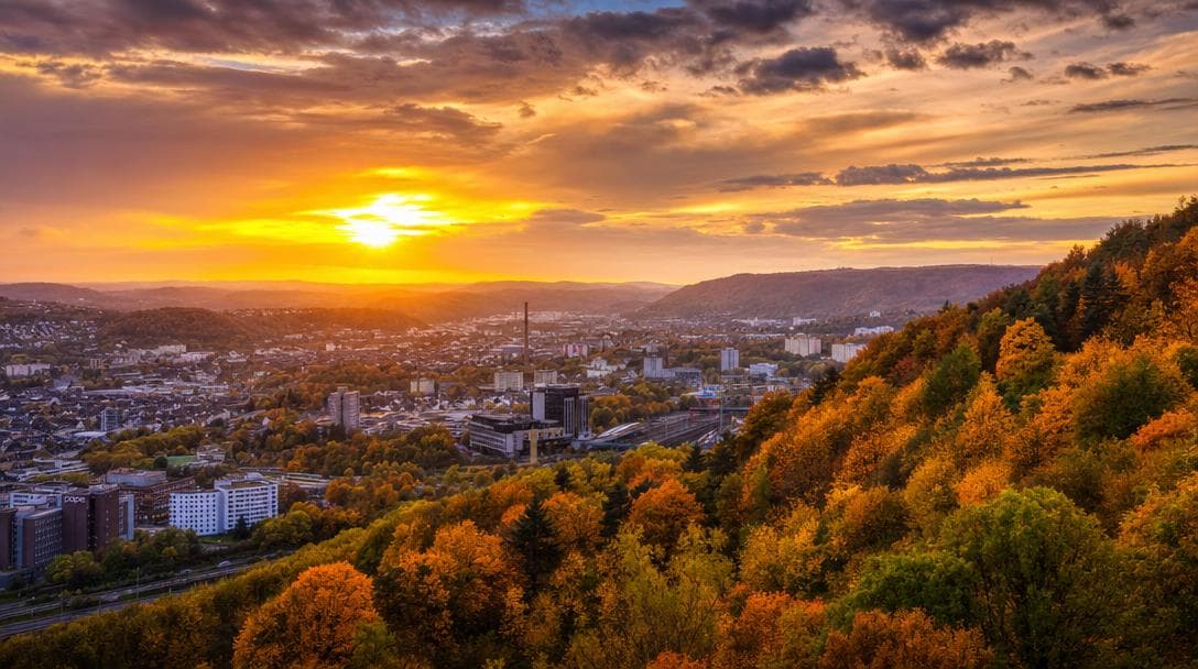 City panorama between wooded hills in the evening light