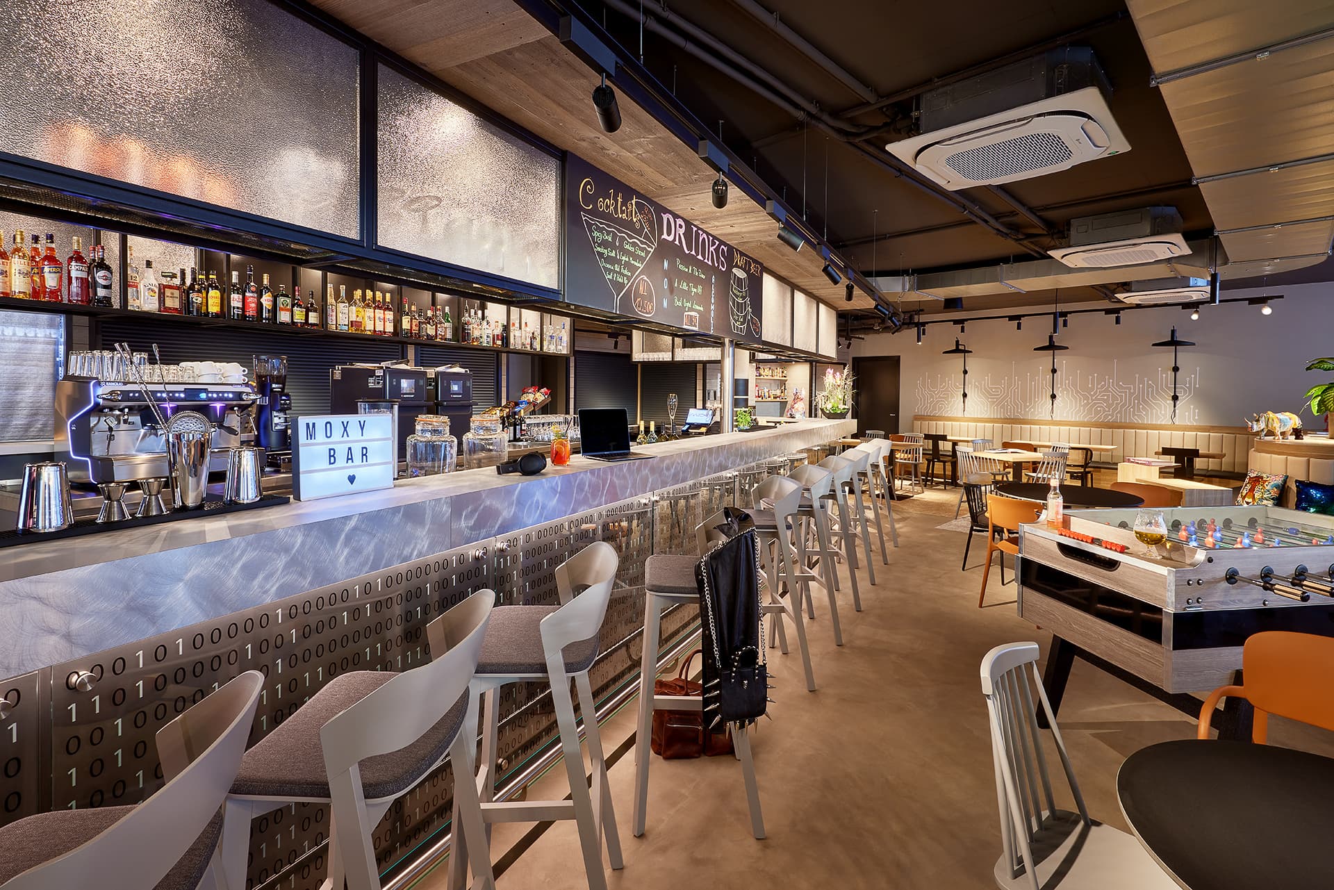 Barbereich im Moxy Hotel Karlsruhe mit Hockern und offenen Sitzbereichen