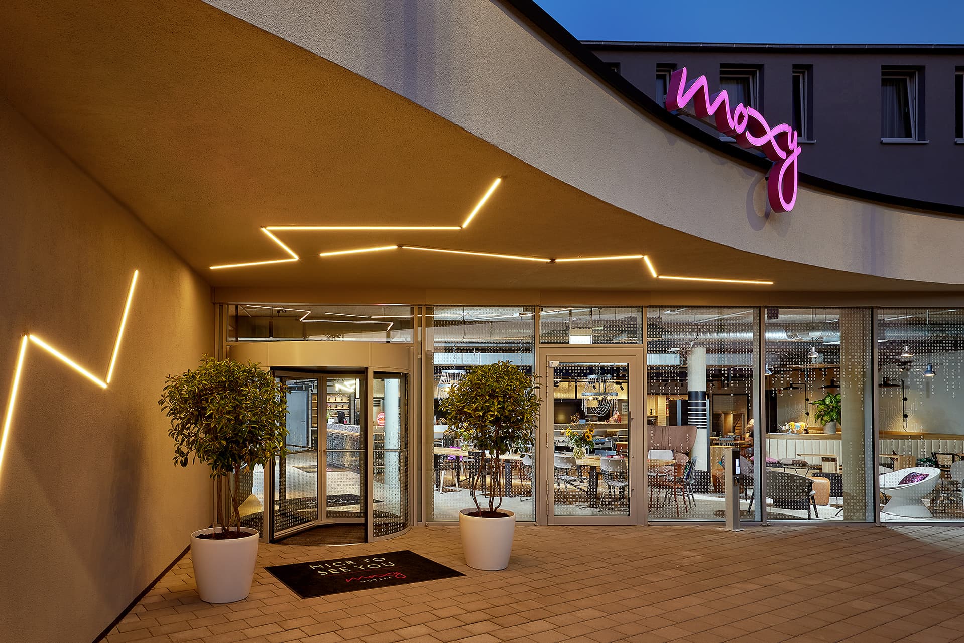 Beleuchteter Eingang des Moxy Hotels Karlsruhe