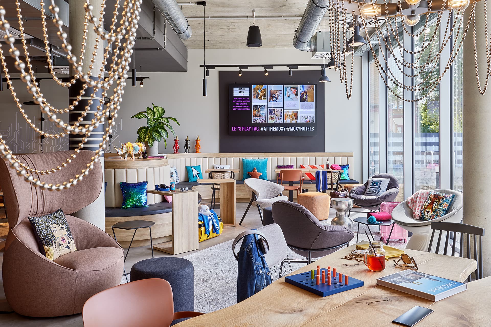 Lounge im Moxy Hotel Karlsruhe mit Sesseln und Tischspielen