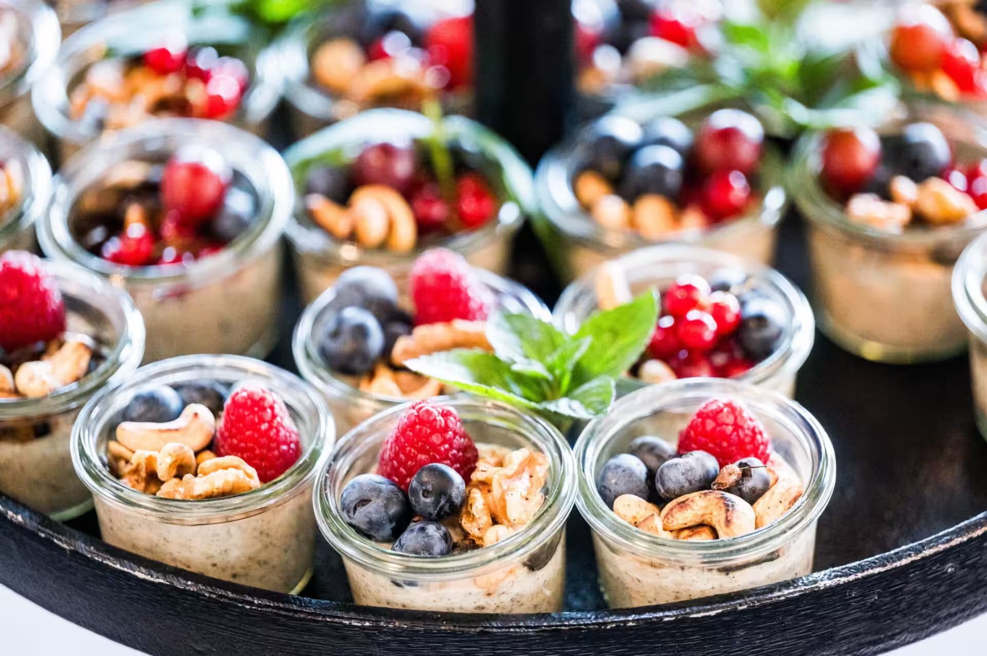 Desserts in Gläsern mit Beeren und Nüssen
