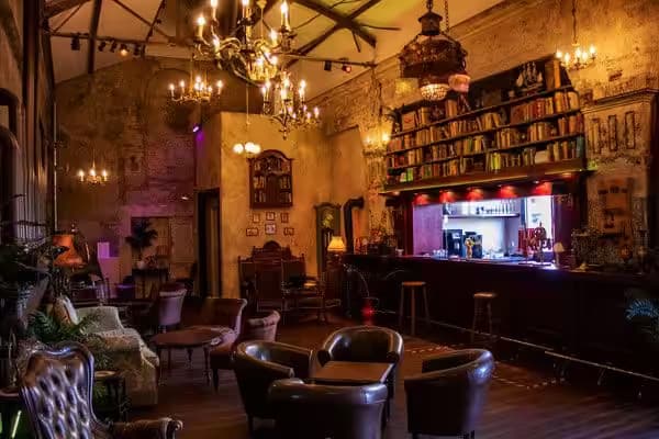 Cosy vintage bar with leather furniture and chandeliers.