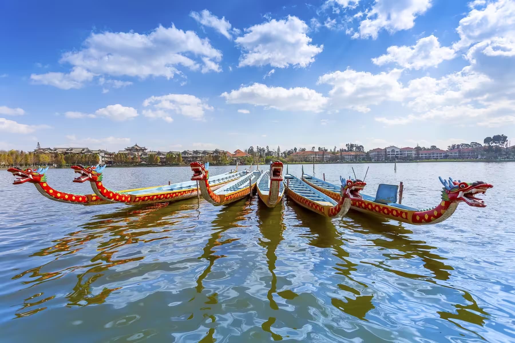 Dragon boats waiting side by side on the water