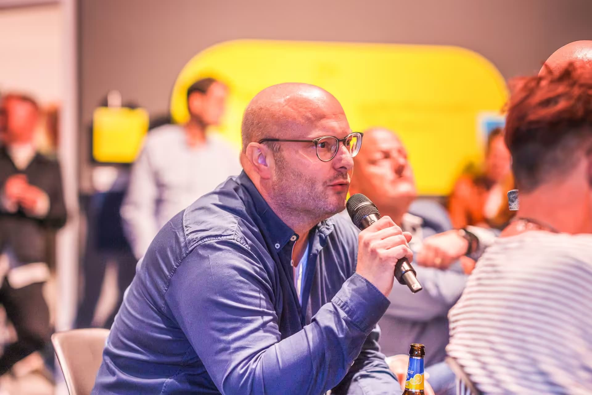 Mann mit Mikrofon bei einer Konferenz.