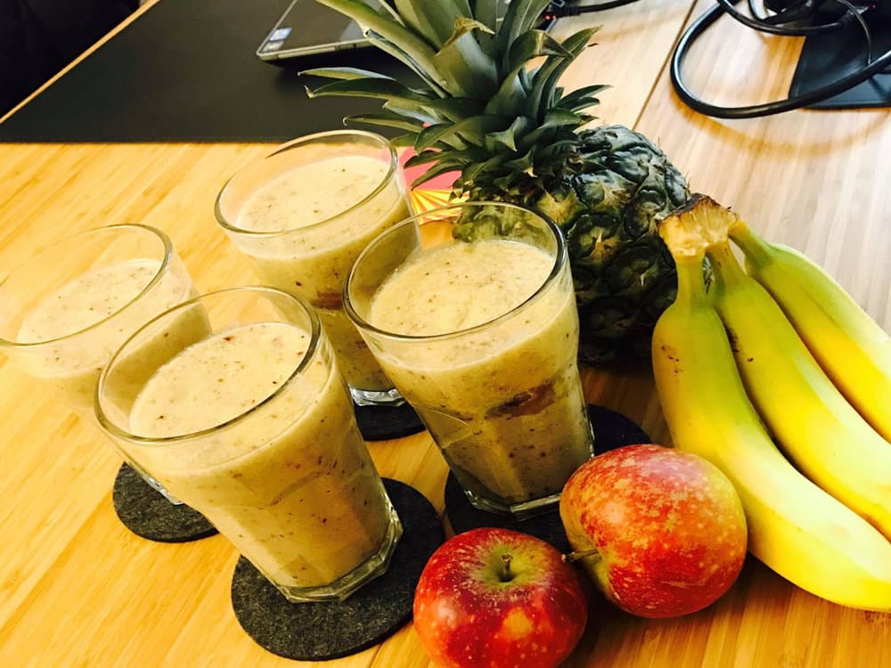 Freshly prepared smoothies with pineapple, bananas and apples
