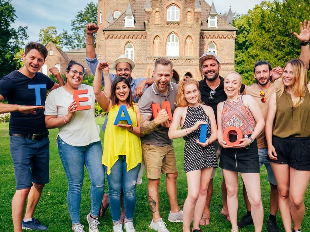 Participants showing colourful letters they have decorated together at a team event