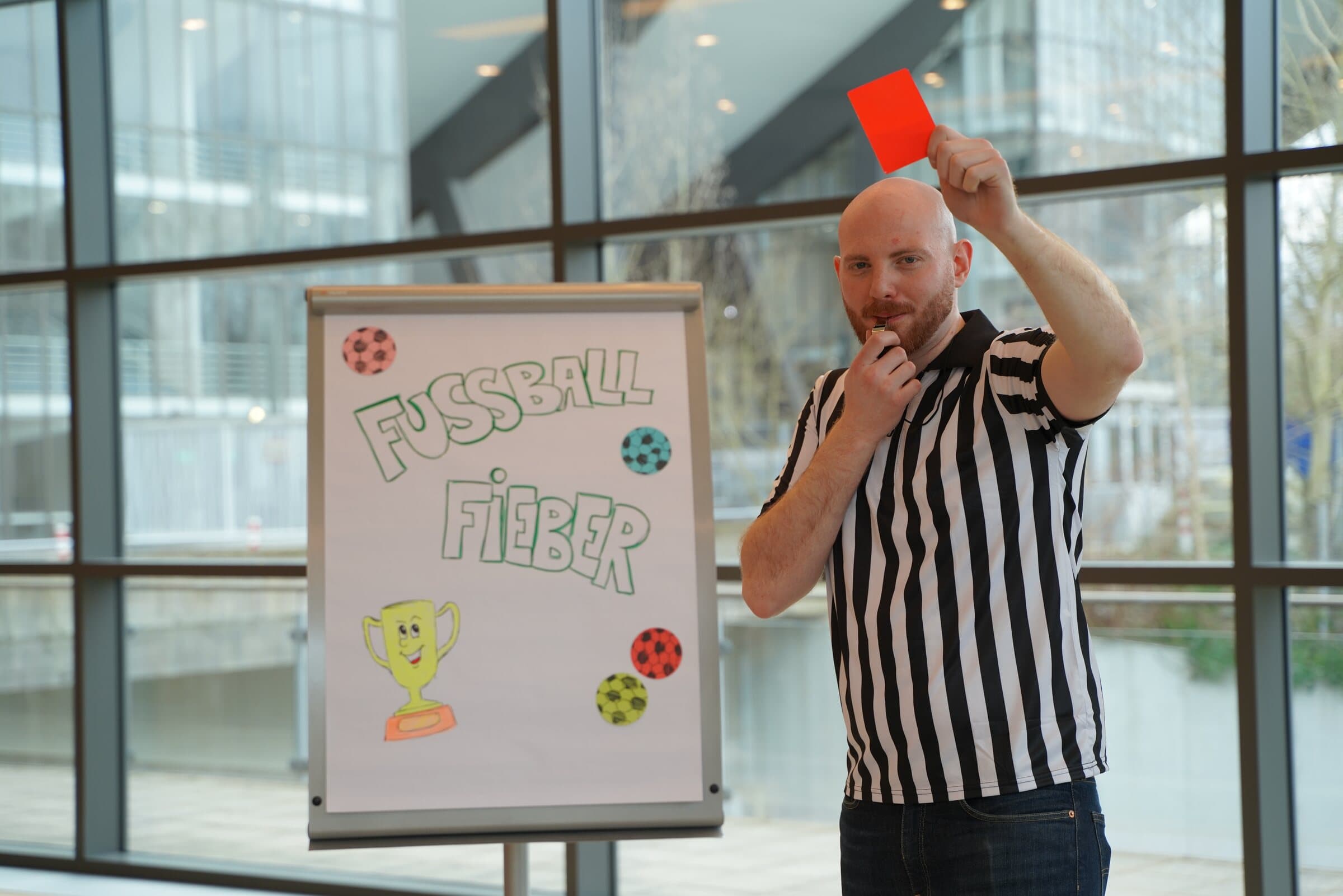 Schiedsrichter zeigt eine rote Karte neben dem Fußball-Fieber-Flipchart