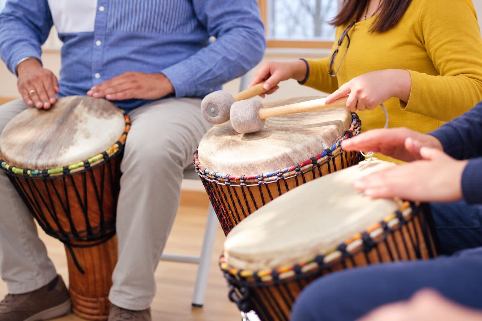 Hände auf Djemben, eine Teilnehmerin spielt mit Schlägeln