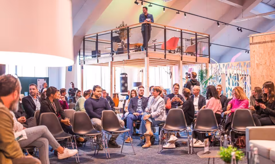 Leute versammeln sich zu einem Veranstaltung in modernem Raum.