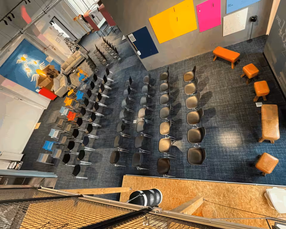 Moderner Konferenzraum mit Stühlen in Reihen angeordnet.