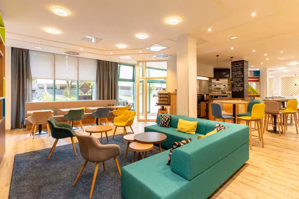 FOUR Essen City Centre Lobby mit bunten Möbeln und Bar