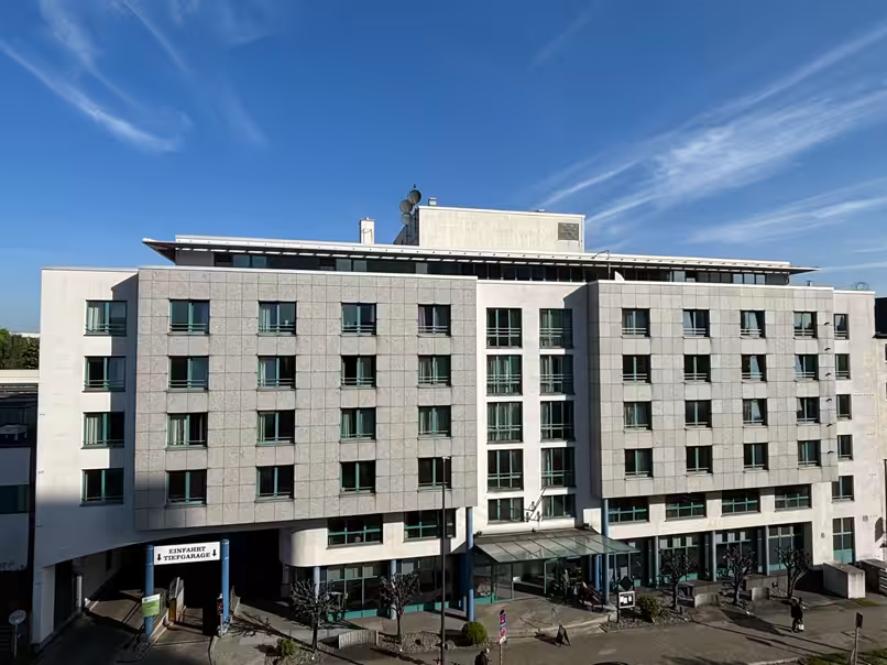 FOUR Essen City Centre - Hotelgebäude mit Tiefgarageneinfahrt, blauer Himmel