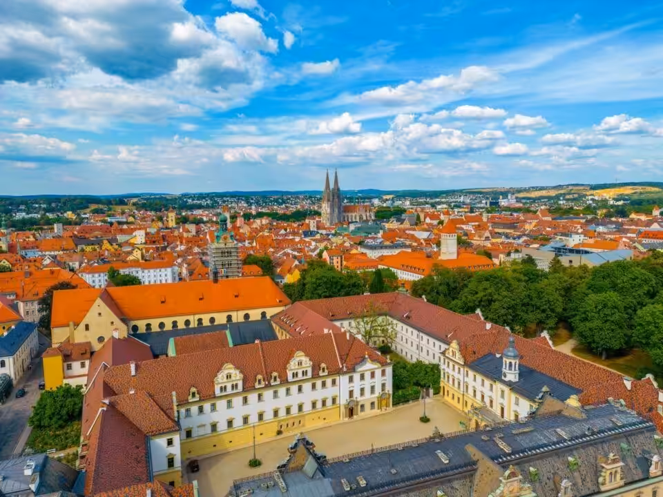 Luftaufnahme einer historischen Stadt mit roten Dächern.