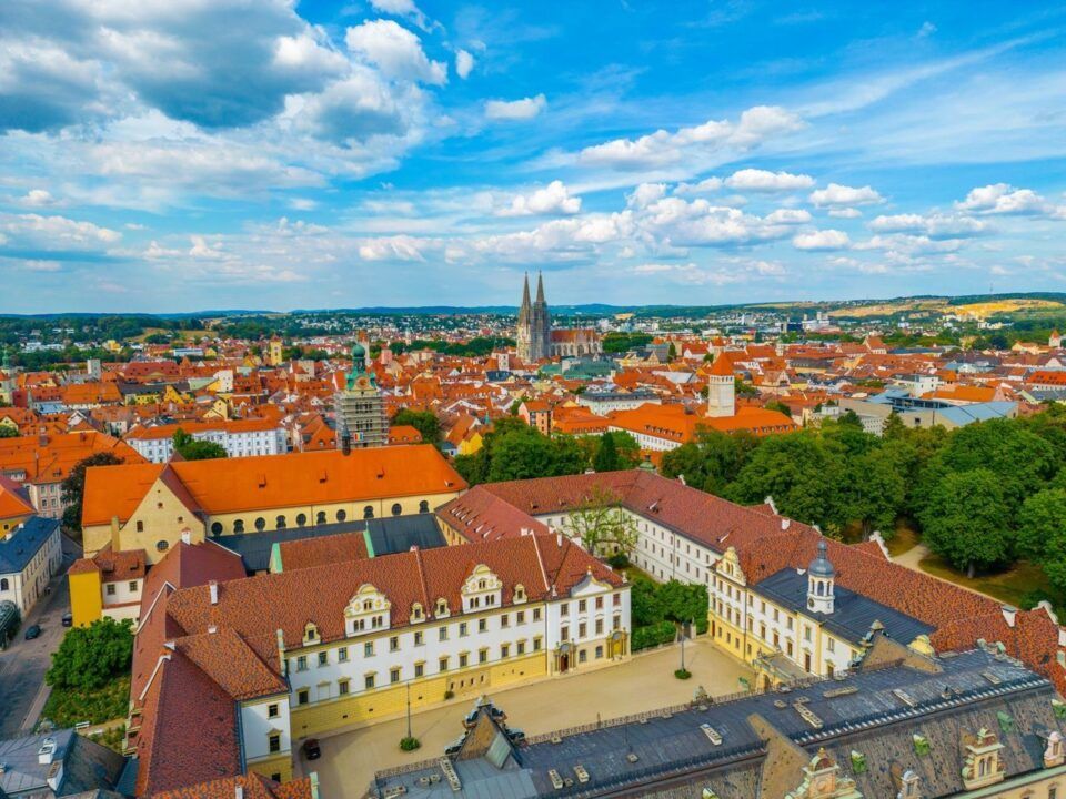 Luftaufnahme einer historischen Stadt mit roten Dächern.