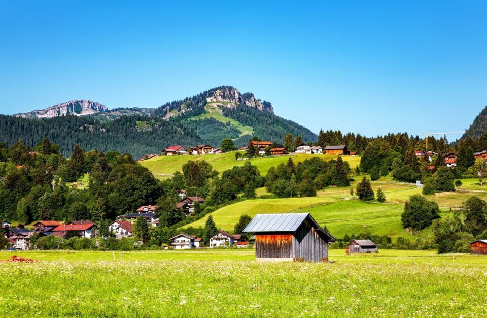 Berglandschaft mit Wiese und Häusern im Allgäu