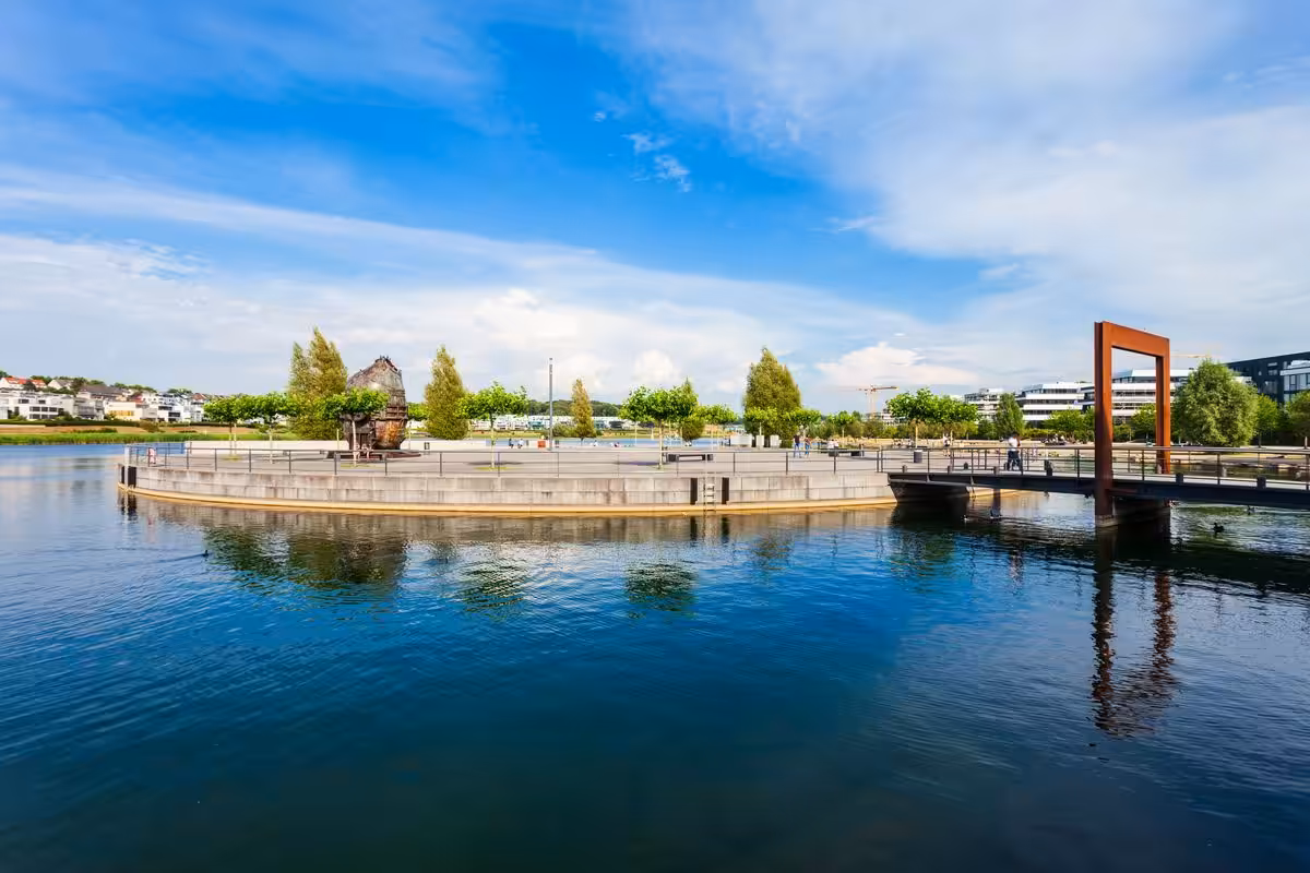Rundinsel mit Brücke auf See vor blauem Himmel in Dortmund