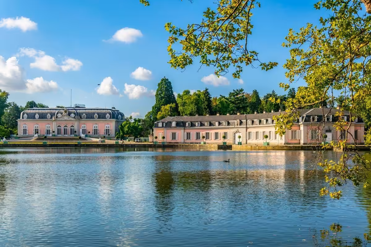 Schloss vor Teich und Bäumen bei klarem Himmel in Düsseldorf