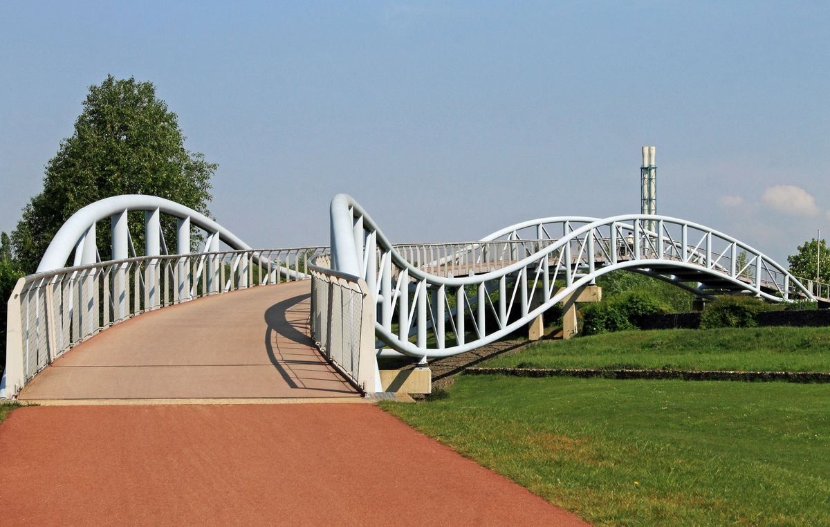 Moderne Fußgängerbrücke über grüner Wiese in Leverkusen