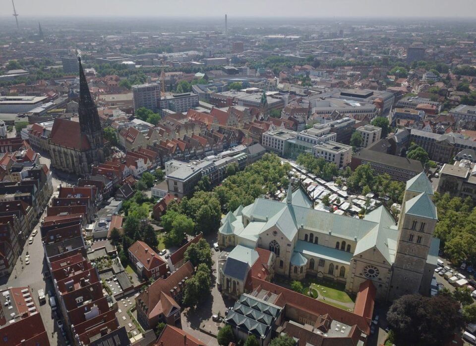 Luftaufnahme von der deutschen Stadt Münster mit Kirche und Häusern.