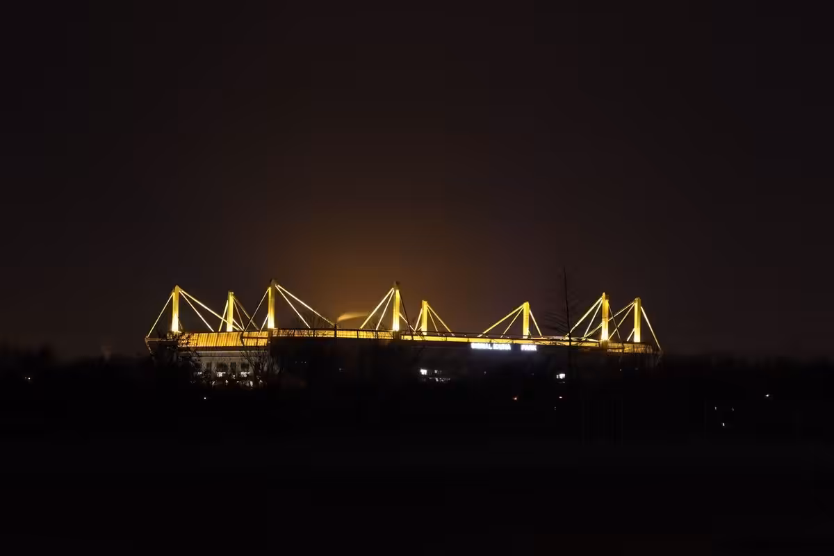 Stadion bei Nacht mit gelber Beleuchtung.