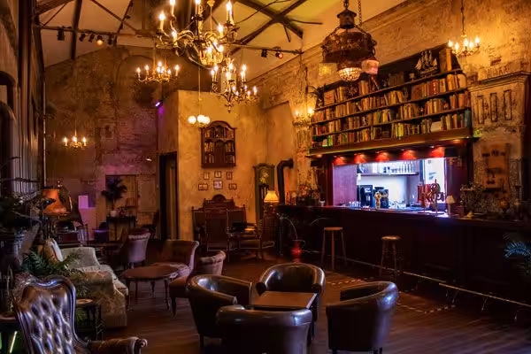 Gemütliche Vintage-Bar mit Ledermöbeln und Kronleuchtern.