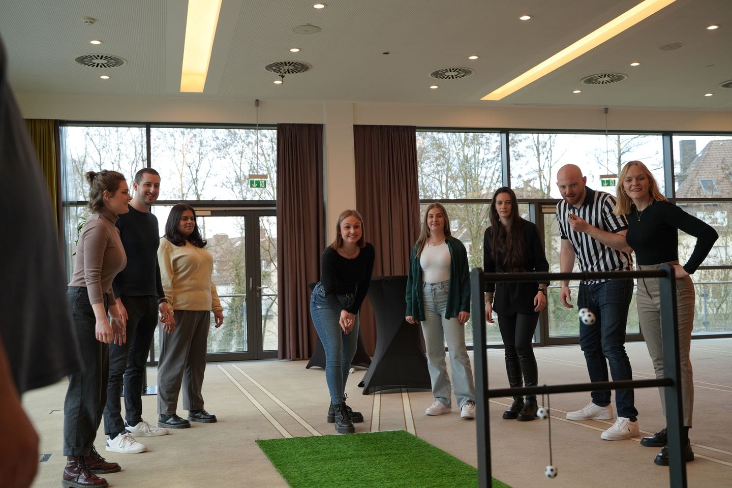 Gruppe spielt im Raum ein Wurfspiel mit Bällen.