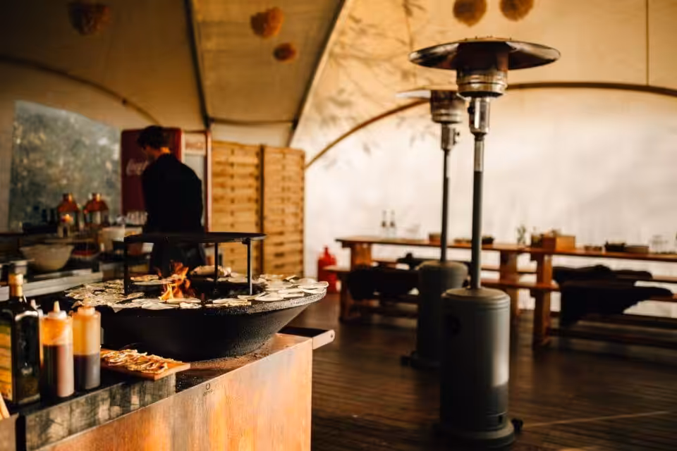 Outdoor-Grillbereich mit Tischen und Zeltdach