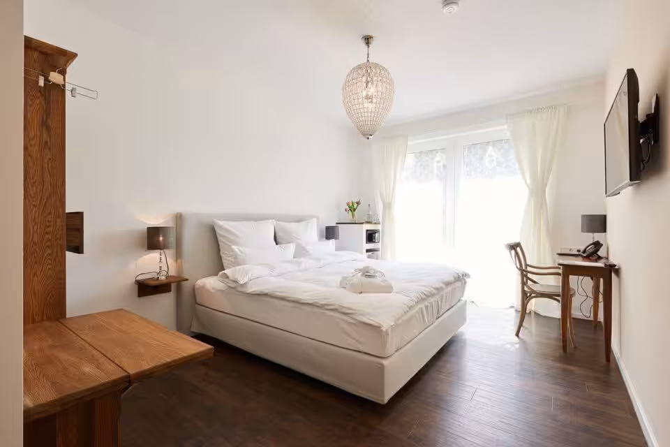 Helles Schlafzimmer mit Doppelbett und Holzmöbeln.