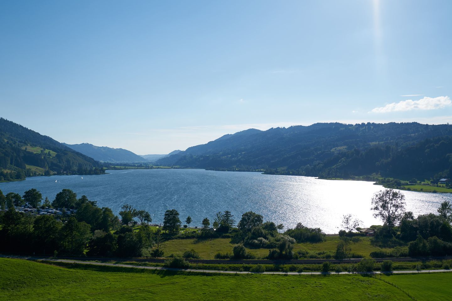 Sonniger See mit Bergen im Hintergrund