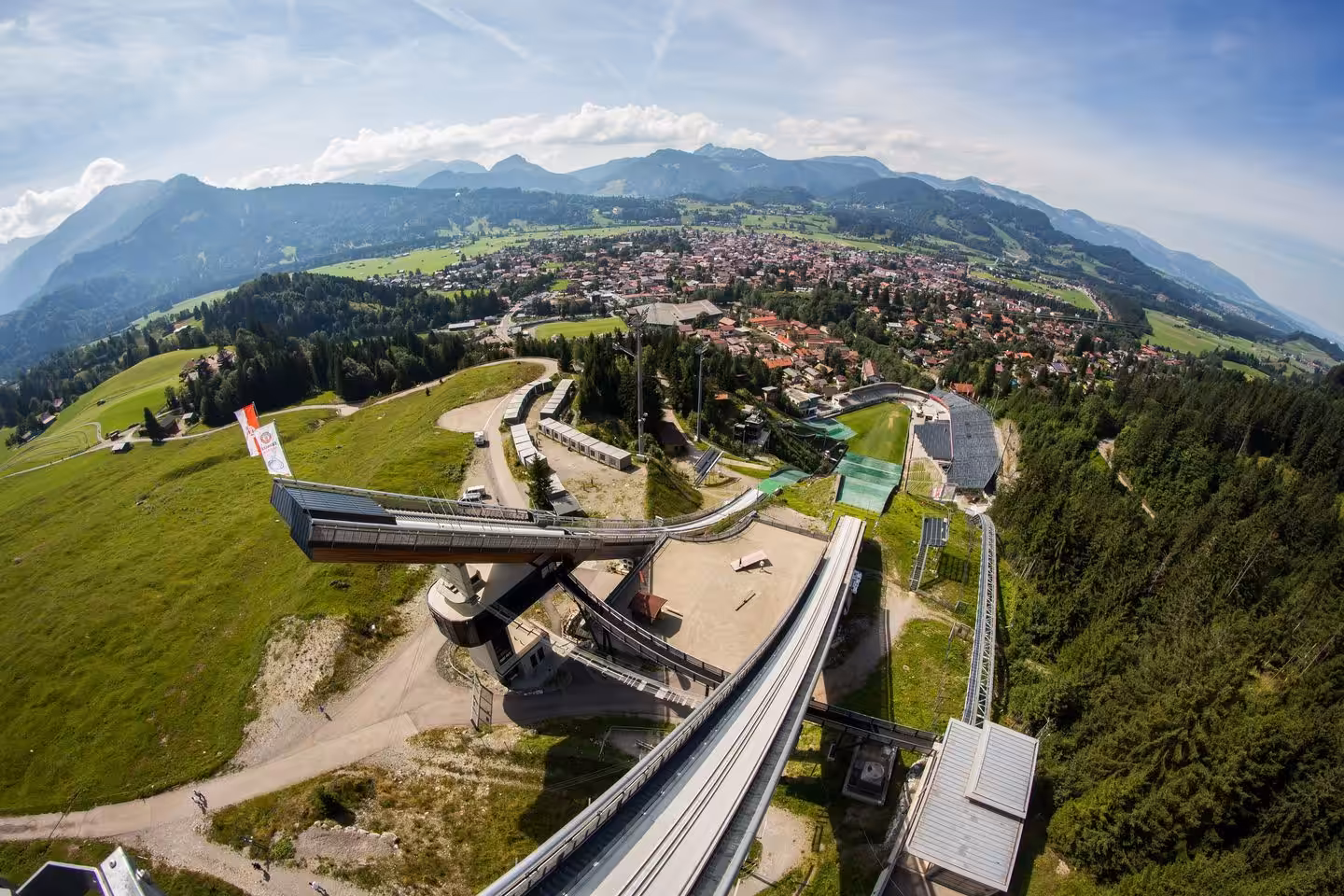 Landschaftsansicht mit Skisprungschanze und Bergpanorama